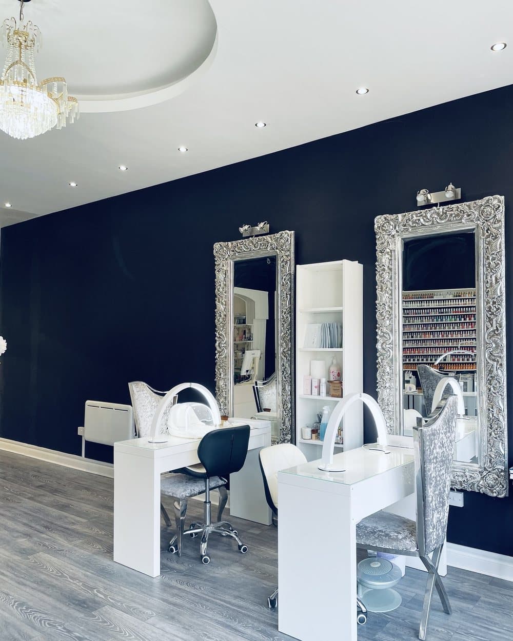 Two desks under tall silver mirrors