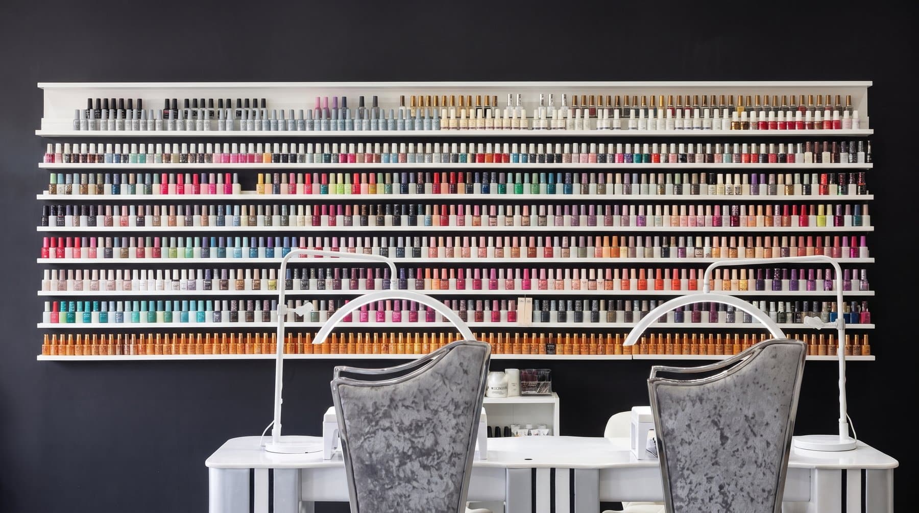 The wall of gel polish colours above the nail desks